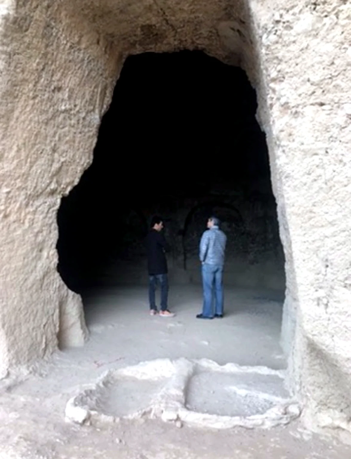 Visitors inside a historic Buddhist cave niche in Bamyan